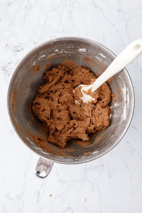 Overhead shot looking down into mixing bowl with finished cookie dough and spatula.