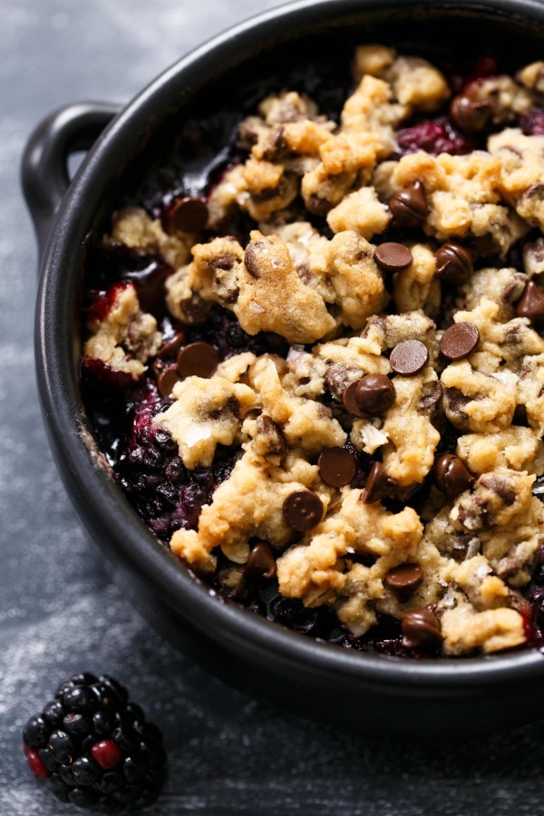 Closeup of baking dish with oatmeal chocolate chip cookie crumble on top of blackberries