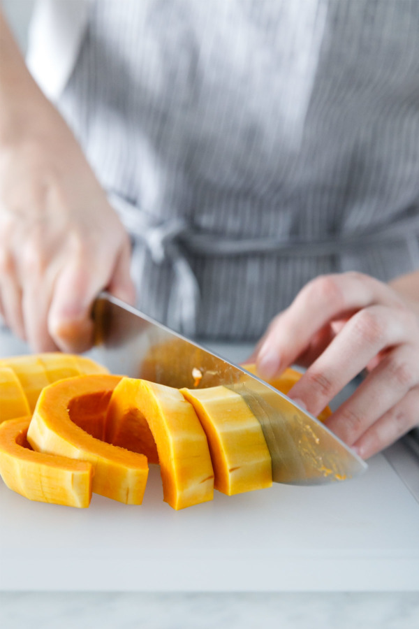 Slice honeynut squash into thick rings for roasting.