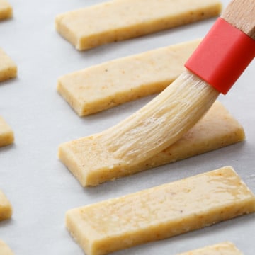 Brushing Parmesan Puffs with egg wash before baking