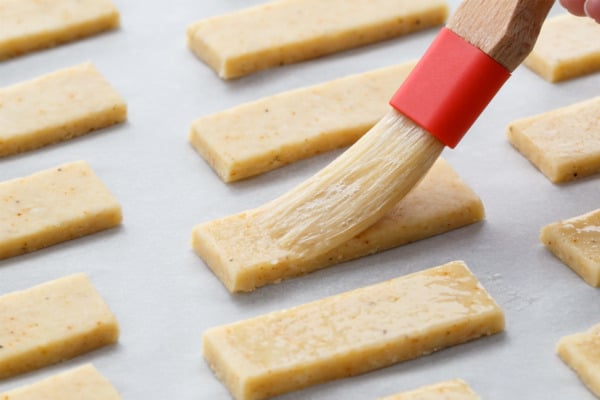 Brushing Parmesan Puffs with egg wash before baking