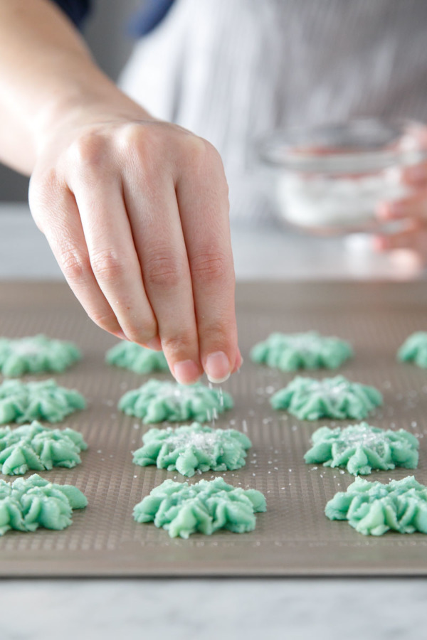 Spritz Cookie snowflakes sprinkled with sanding sugar and edible glitter.