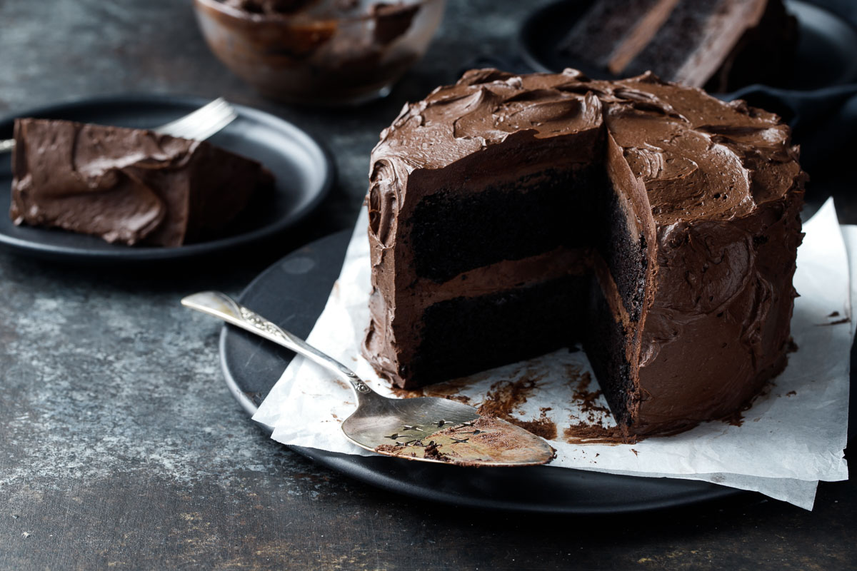 Dark, fudgy and ultra-moist chocolate layer cake slathered with a dark choc...