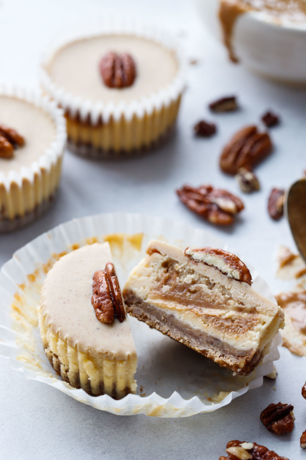 Pecan Praline Mini Cheesecakes, cut in half to reveal the swirl of pecan praline inside.