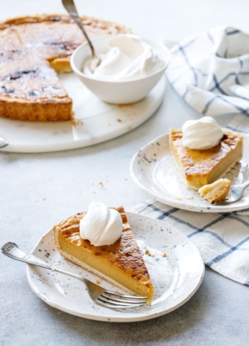 Slice of Pumpkin Custard Tart recipe served with fresh whipped cream