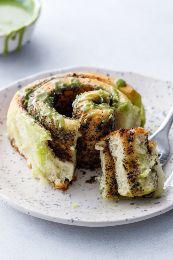 Soft and fluffy cinnamon roll recipe with a black sesame filling and sweet matcha glaze