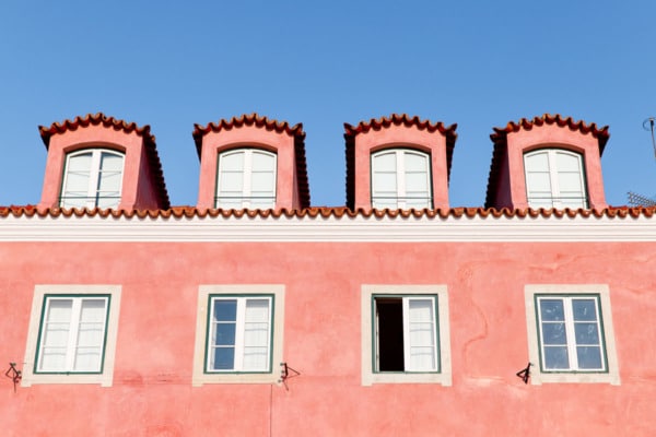 Coral pink building against a bright blue sky.