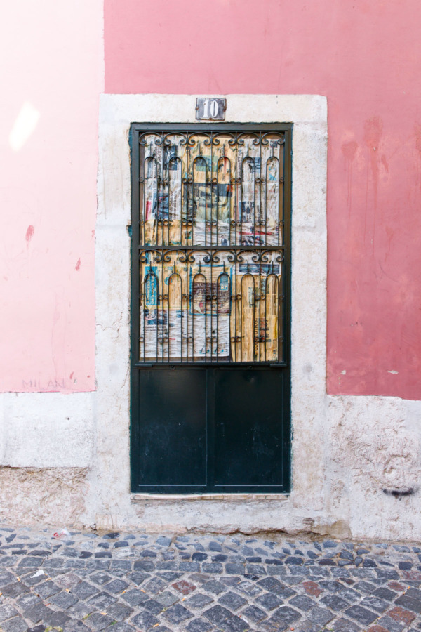 Colorful pink walls and ornate ironwork door in Lisbon, Portugal