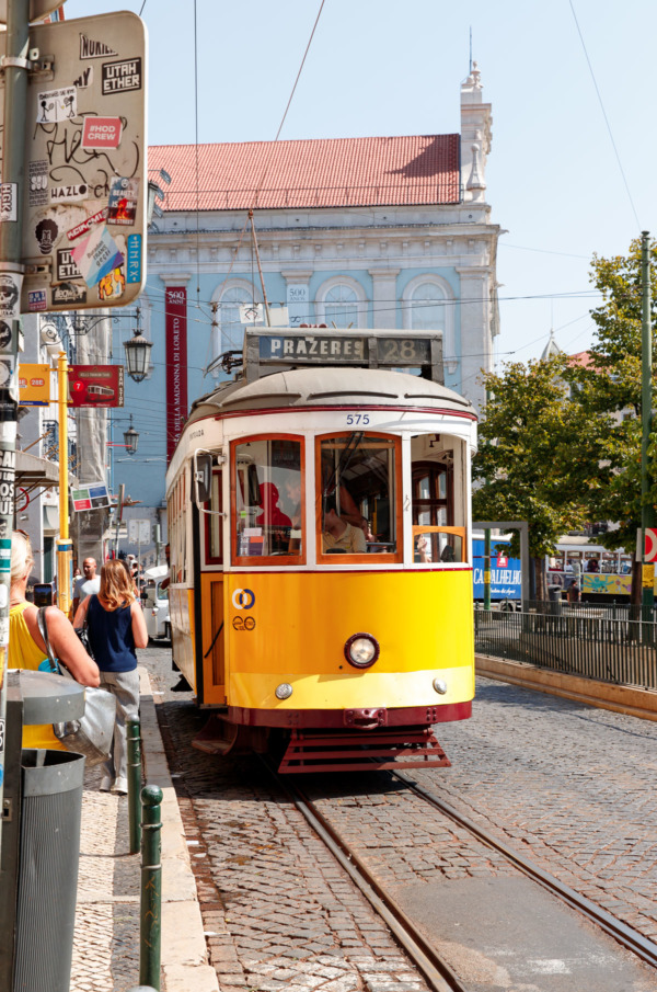 The 28E tram letting people on at a bus stop in Lisbon, Portugal