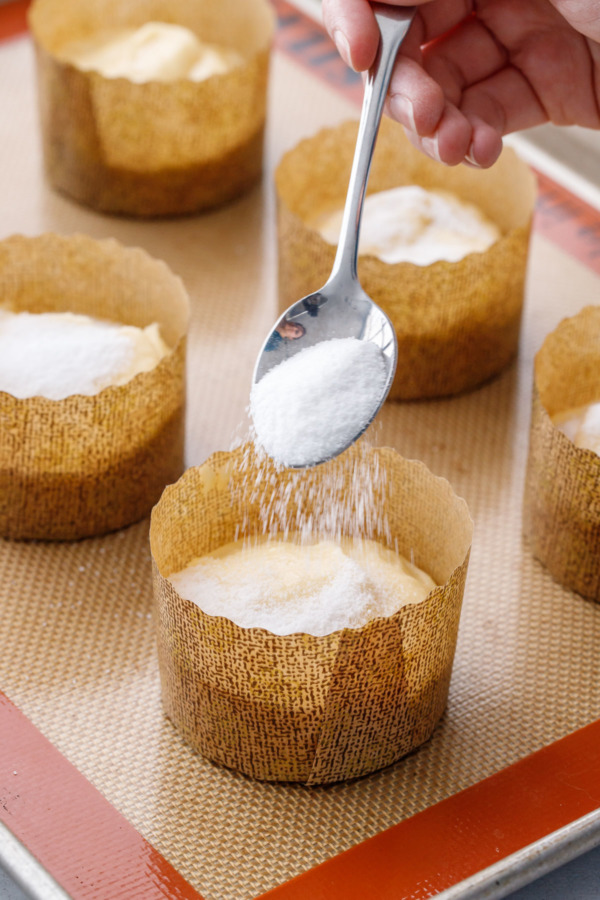 Sprinkling sugar on top of the muffin batter prior to baking.