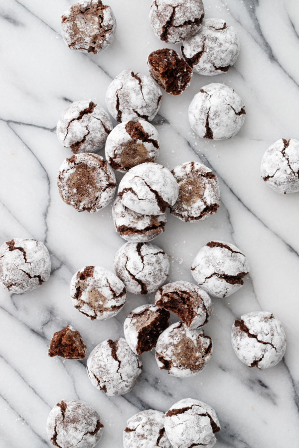 Overhead shot of Chocolate Amaretti Cookies strewn over a marble surface.