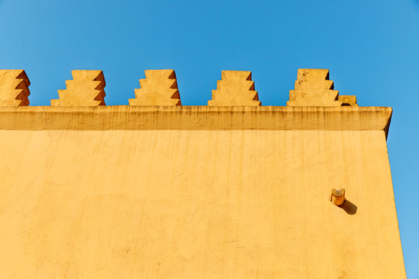 Geometric yellow walls against a bright blue sky in Sintra, Portugal