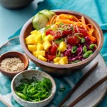 Ahi Mango Poke served in a wooden bowl on a turquoise background.