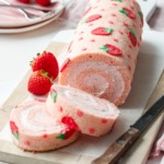 Two slices of a strawberry cake roll, showing the spiral shape and whipped cream filling.