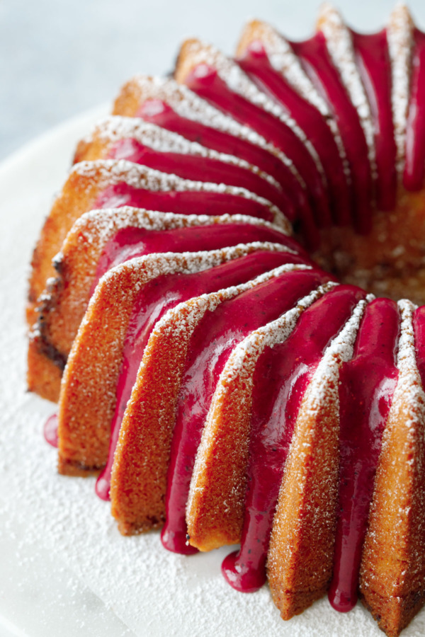 Close up showing the hot pink strawberry hibiscus glaze on the sugar-dusted bundt cake.