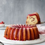A slice of strawberry hibiscus pound cake being lifted with a cake server.