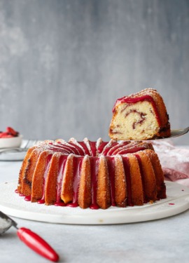 A slice of strawberry hibiscus pound cake being lifted with a cake server.