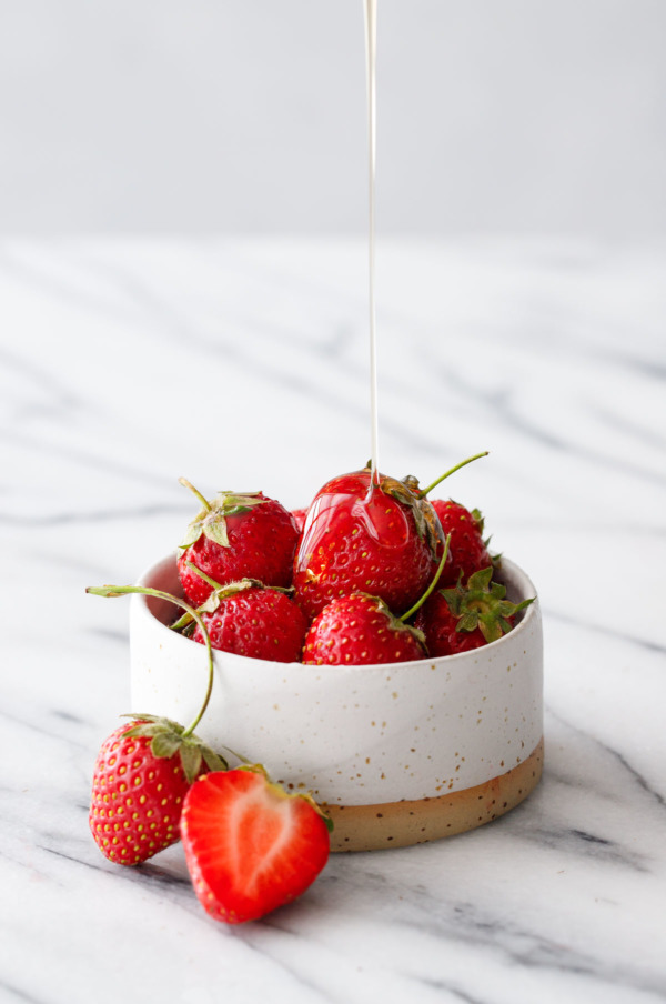 Ceramic dish filled with strawberries, drizzled with agave nectar.