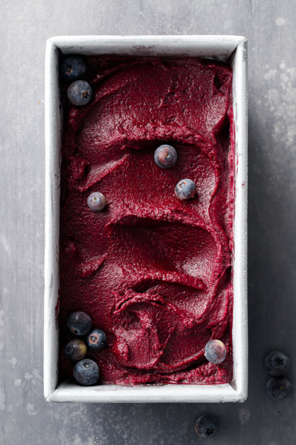 Overhead shot of metal loaf pan filled with a swirl of Blueberry Ginger Sorbet