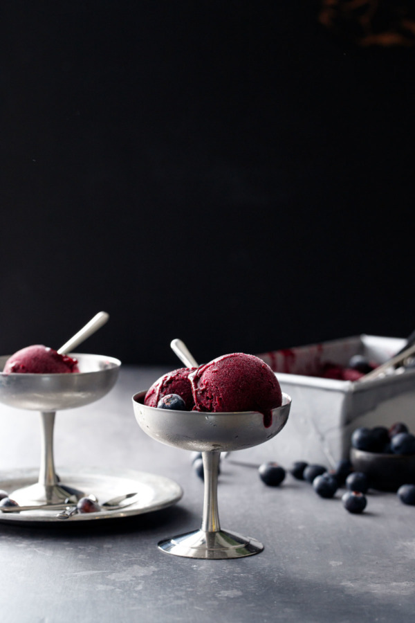 Moody shot of scoops of Blueberry Ginger Sorbet in pewter pedestal dishes