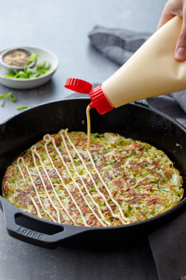Drizzling okonomiyaki with kewpie mayonnaise