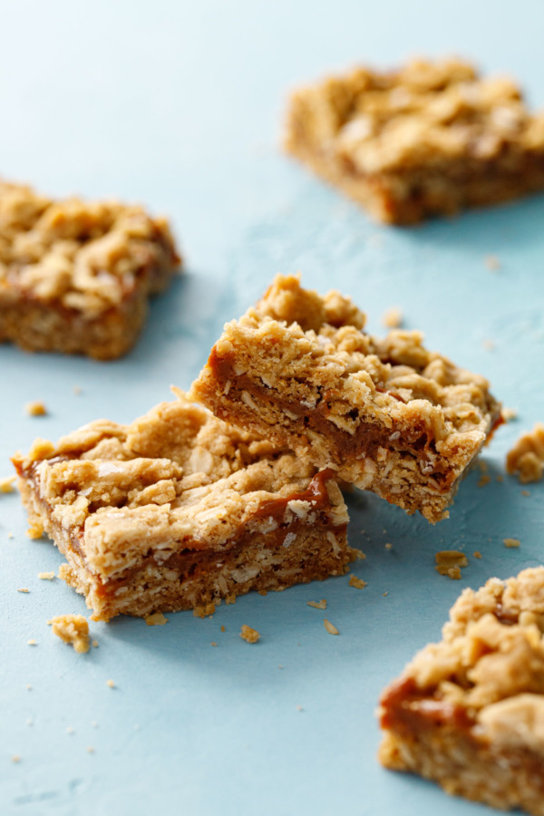 Dulce de Leche Oatmeal Crumb Bars on a light blue background