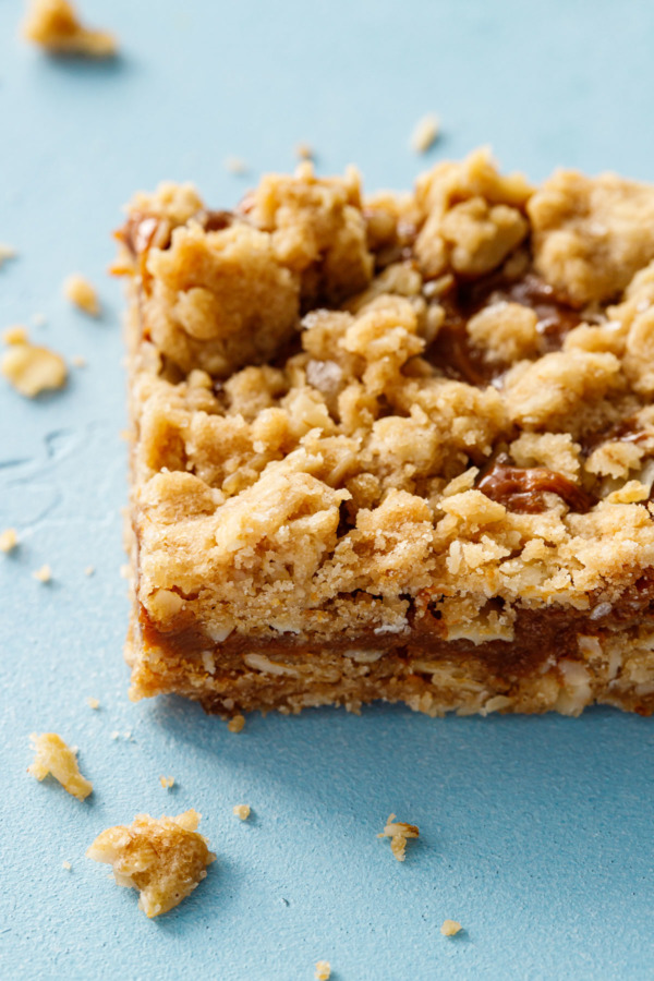 Closeup of one square of Dulce de Leche Oatmeal Crumb Bars with crumbs 