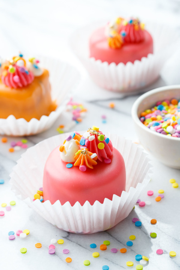 Pink and orange glazed 'funfetti-four' with rainbow sprinkles.