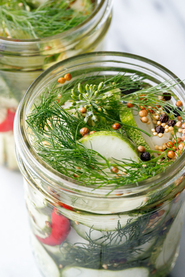 The jars should be full to the rim with brine, if not, top off with filtered water so the cucumbers are completely covered.