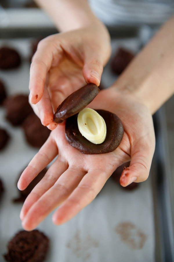 How to stuff a chocolate cookie with white chocolate: sandwich white chocolate feves between two flattened pieces of chocolate cookie dough.