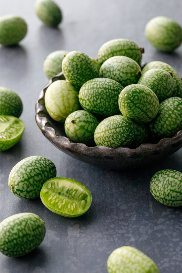 Handmade ceramic dish overflowing with tiny cucamelons.