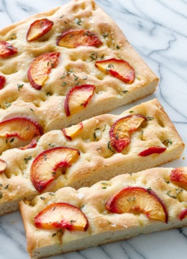 Peach & Fresh Herb Focaccia Bread on a marble background cut into slices