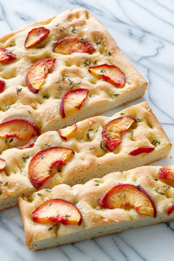 Peach & Thyme Focaccia Bread on a marble background cut into slices