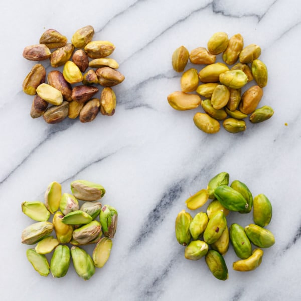 Comparison shot showing pre-peeled pistachios (raw and blanched) and pistachios that have been freshly shelled (raw and blanched/peeled).