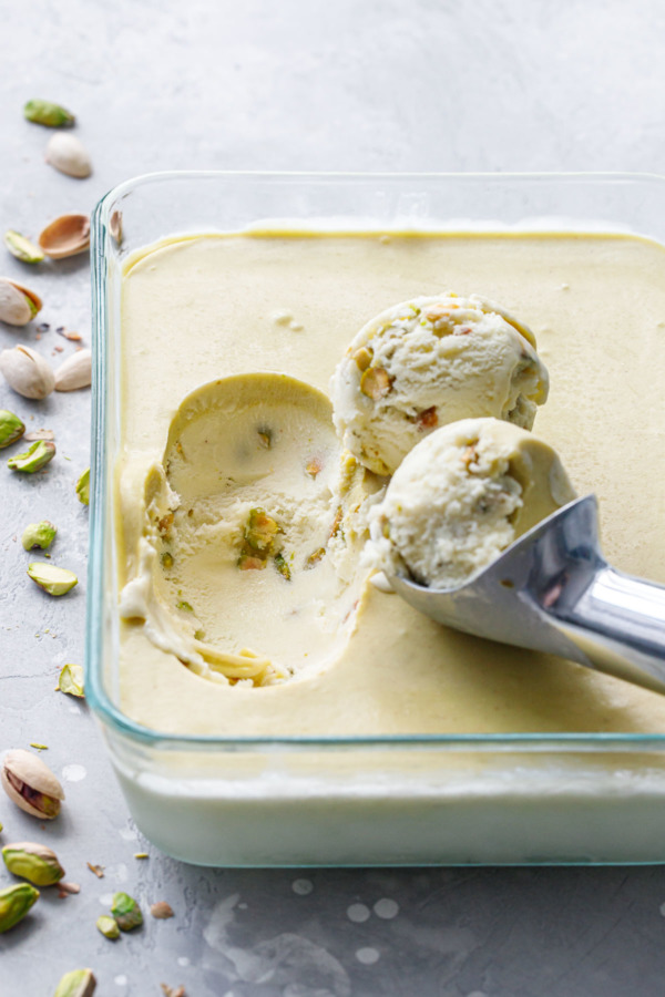 Scoops of pistachio gelato in a shallow dish with a layer of pistachio cream on top.