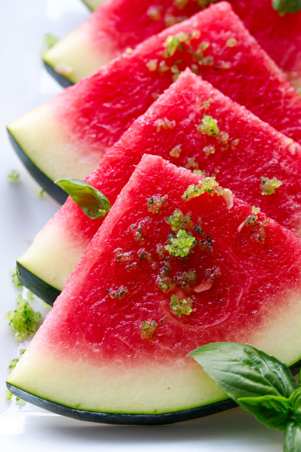 Closeup of watermelon slices, sprinkled with basil lime sugar