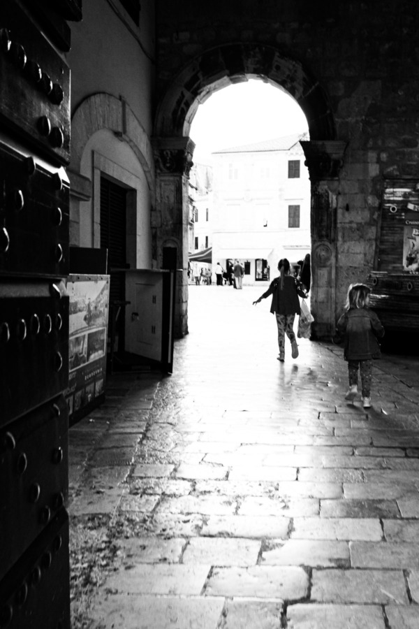 Little girls running through an archway in Dubrovnik, Croatia