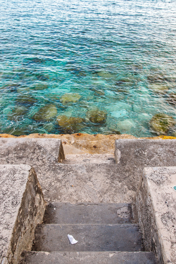 Stairs leading town to vibrant turquoise water in Dubrovnik, Croatia