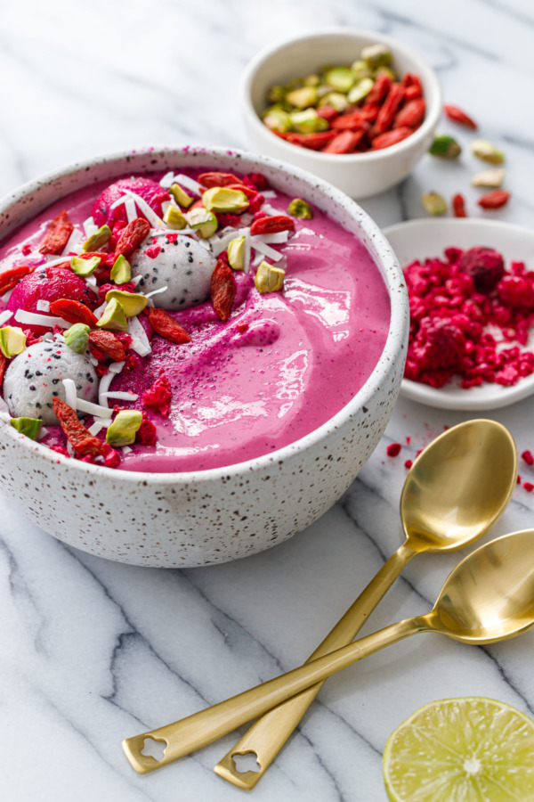 Dragonfruit Smoothie Bowls topped with goji berries, pistachios and freeze-dried raspberries.