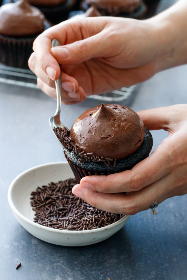 Use a small spoon to press chocolate sprinkles around the edges of the frosting.