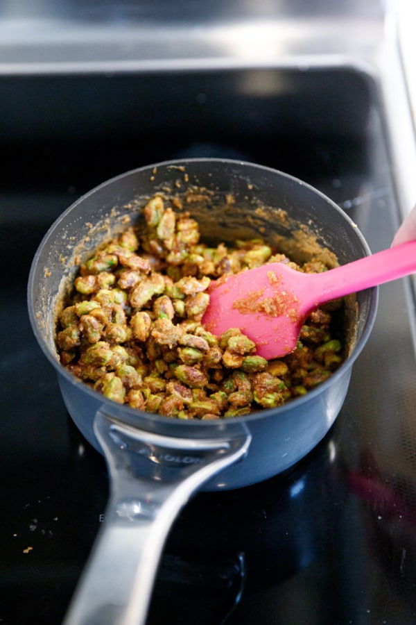 Stirring pistachios in a small saucepan on the stovetop—as the syrup cools it will begin to crystalize, ultimately looking something like wet sand.