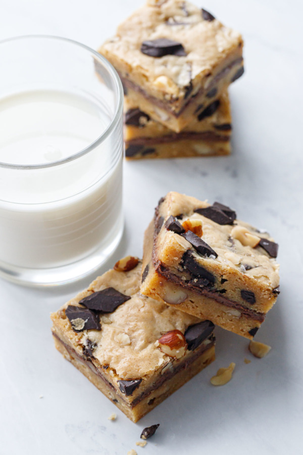 Square cut Nutella-Stuffed Brown Butter Blondies and a glass of milk.
