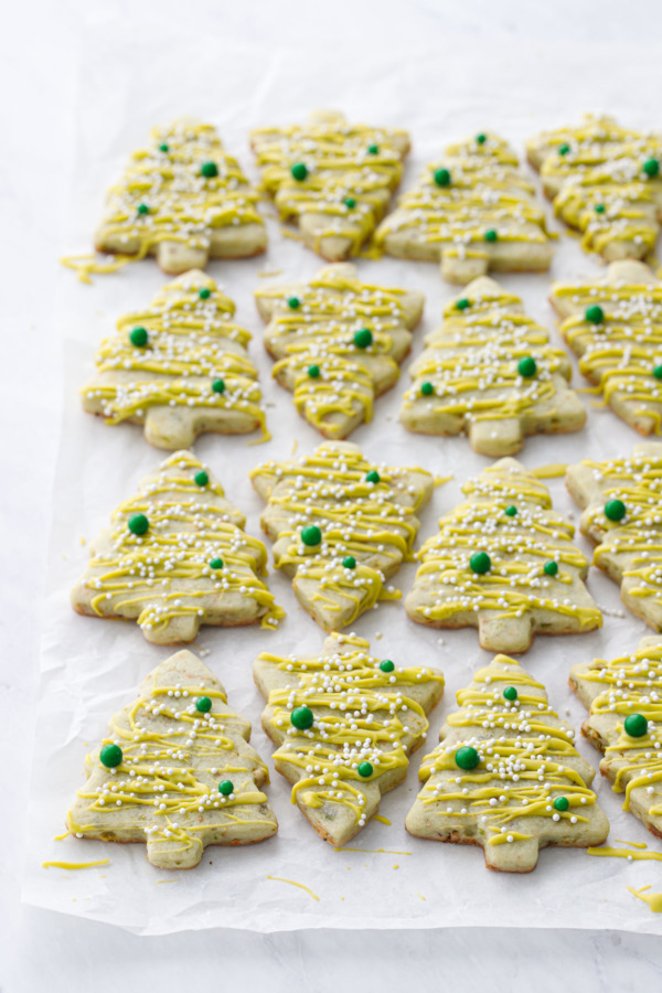 Tree-shaped pistachio sugar cookies arranged on a crinkled piece of parchment