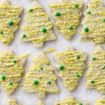 Alternating tree-shaped pistachio cut out cookies on parchment paper