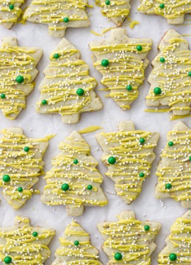 Alternating tree-shaped pistachio cut out cookies on parchment paper