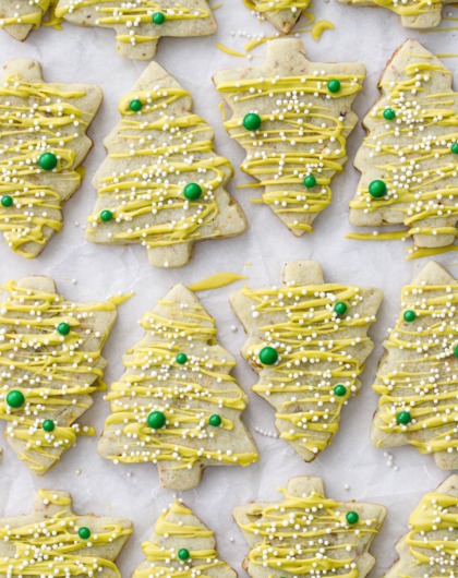 Alternating tree-shaped pistachio cut out cookies on parchment paper