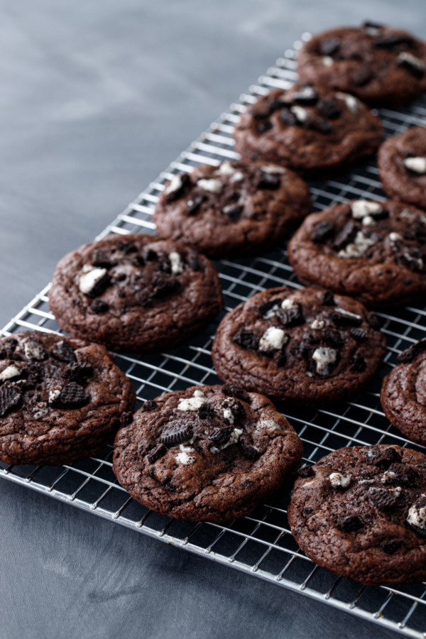 Rows of Cookies 'n Cream Stuffed Chocolate Cookies arranged on a chrome wire cooling rack