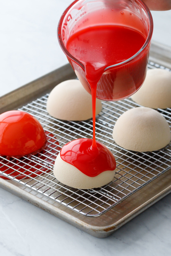 How-To Entremet Cake Process: pour the mirror glaze over the frozen mousse domes set on a wire rack so the excess flows off.