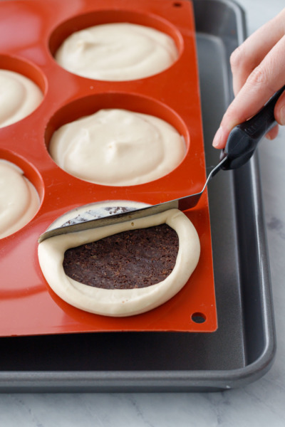 How-To Entremet Cake Process: scrape off the excess mousse so the top of the dome is level.