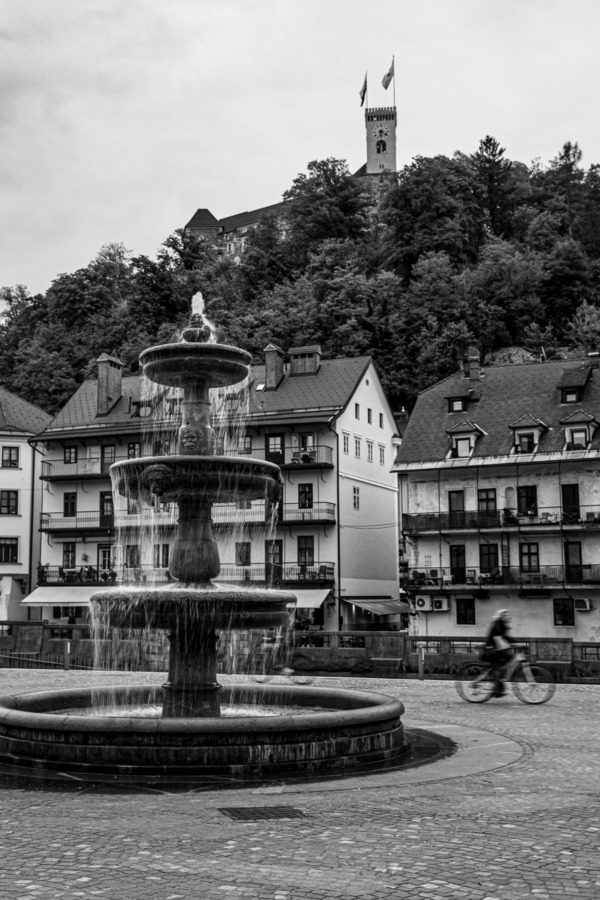 Black and white Novi Trg square and fountain looking towards the castle in Ljubljana, Slovenia